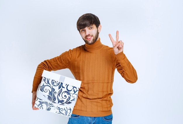 Happy Man with White Gift Box and Blue Patterns – Free Stock Photo for Download