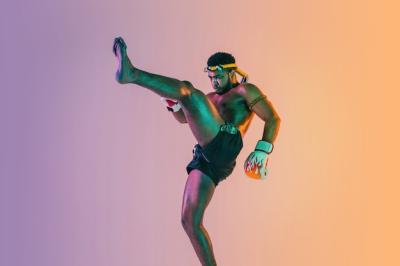 Dynamic Muay Thai Training: Young Man Practicing Thai Boxing in Neon Light – Free Stock Photo