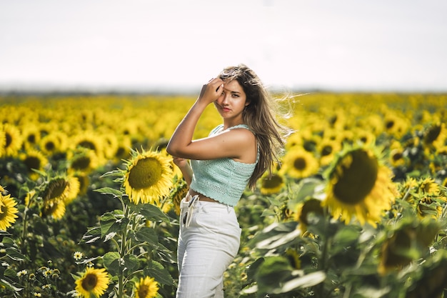 Young Caucasian Female Posing in a Bright Field of Sunflowers – Free Download