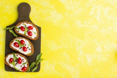 Top View of Bread Toasts with Sour Cream and Dogwoods on Yellow Surface – Free Download