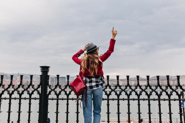 Carefree Woman in Red Backpack Gazing at Cityscape on a Cold Morning – Free Download