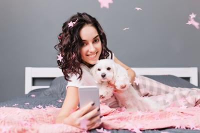 Young Woman in Pajamas Smiling with Dog in Modern Apartment – Free Download