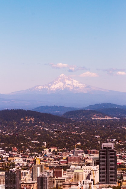 Beautiful Aerial Shot of an Urban City with a Stunning Snowy Mountain – Free Download