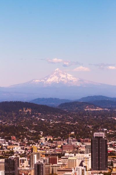 Beautiful Aerial Shot of an Urban City with a Stunning Snowy Mountain – Free Download