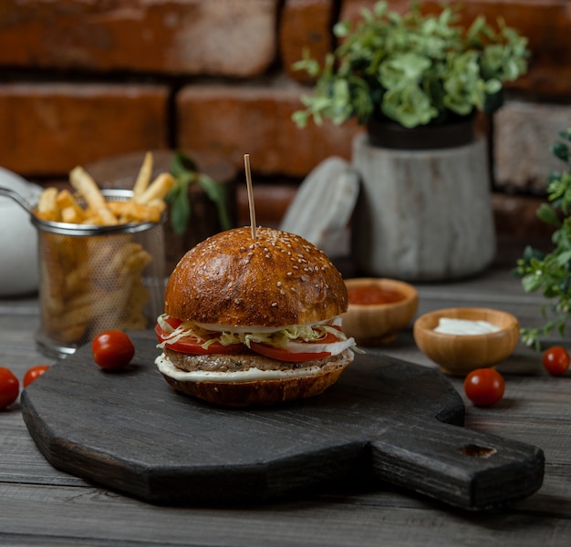 A Delectable Veggie-Stuffed Beef Burger with French Fries – Free Stock Photo for Download