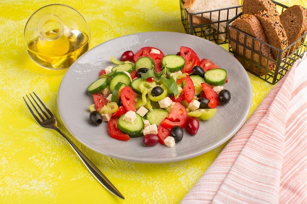 Fresh Vegetable Salad with Cucumbers, Tomatoes, and Olive on Yellow Surface – Free Stock Photo for Download