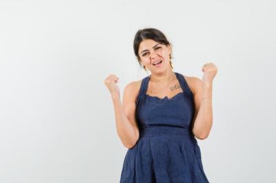 Young Lady Celebrating with Winner Gesture in Dress – Free Stock Photo Download