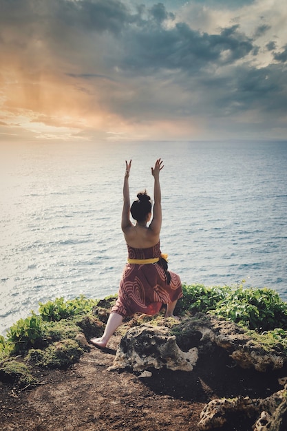 Woman on a Cliff Overlooking the Sea Greeting the Sun – Free Stock Photo, Download for Free