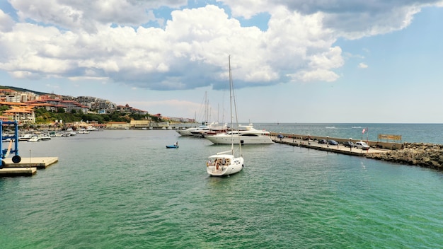 Wide Shot of a Coastal City Dock with Sailboats – Free Download