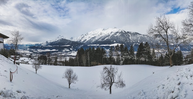 Stunning Mountain Range Surrounded by Pine Trees on a Snowy Day – Free Stock Photo for Download