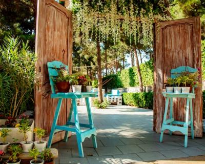 Charming Restaurant Entrance Featuring Wooden Doors and Turquoise Chairs – Free Stock Photo for Download