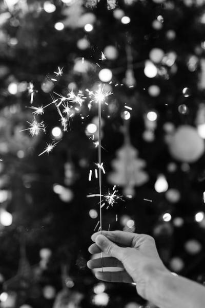 Hand Holding a Sparkler with a Christmas Tree – Free Download