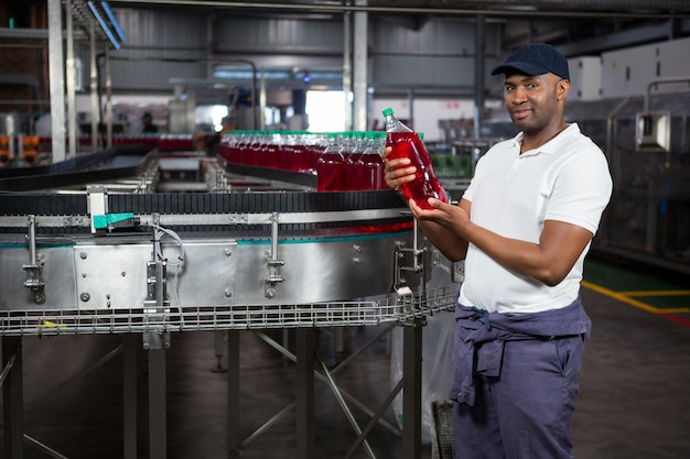 Young Worker Inspecting Juice Bottle at Factory – Free Stock Photo, Download Free Stock Photo