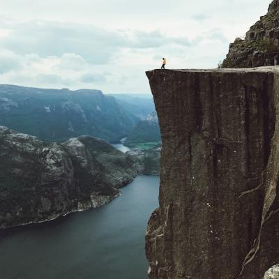 Man in a Yellow Jacket Posing on a Rock – Free Stock Photo for Download