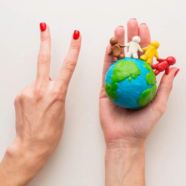 Hands Holding Plasticine Globe and Peace Sign – Free Stock Photo Download