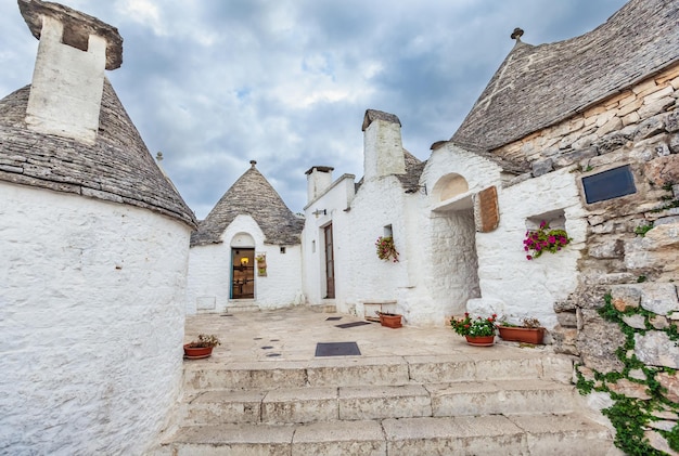 Tranquil Alberobello: Explore the Trulli Houses Surrounded by Lush Greenery and Blossoms – Free Download