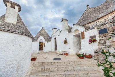 Tranquil Alberobello: Explore the Trulli Houses Surrounded by Lush Greenery and Blossoms – Free Download