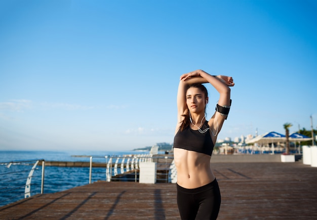 Young Beautiful Fitness Girl Doing Sport Exercises by the Sea Coast – Free Download