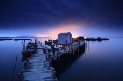 Breathtaking Twilight View of a Wooden Pier and Cottage Over a Calm Ocean – Free Download