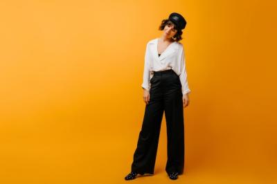 Stylish Woman in Black Pants and Hat â Full-Length Portrait on Yellow Background | Free Stock Photo for Download