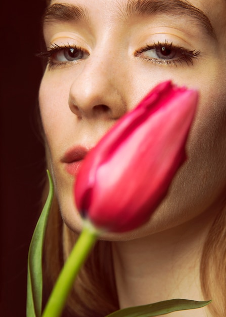 Thoughtful Young Woman Surrounded by Bright Tulips – Free to Download