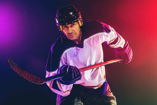 Dynamic Male Hockey Player on Ice Court with Neon Wall – Free Stock Photo for Download