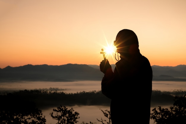 Silhouette of a Hand Holding the Cross at Sunrise – Free Stock Photo, Download for Free