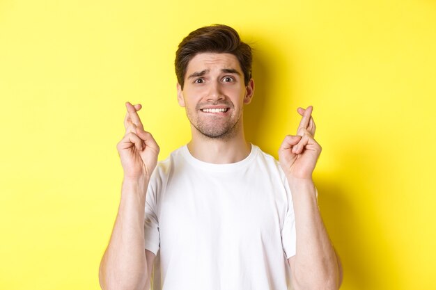 Closeup of Nervous Man Making a Wish with Fingers Crossed and Biting Lip – Free Stock Photo, Download Free