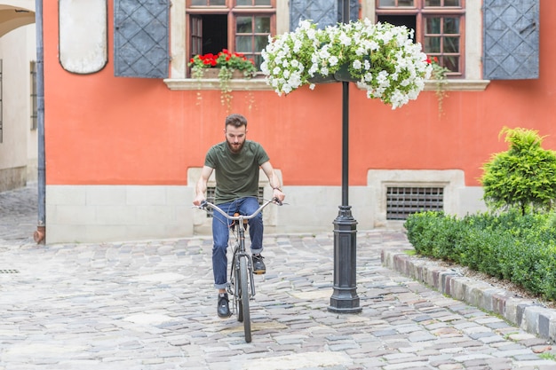 Young Male Cyclist on Cobblestone Pavement – Free Download