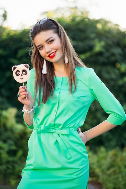 Beautiful Smiling Girl in Green Dress with Candy Panda – Free Stock Photo Download