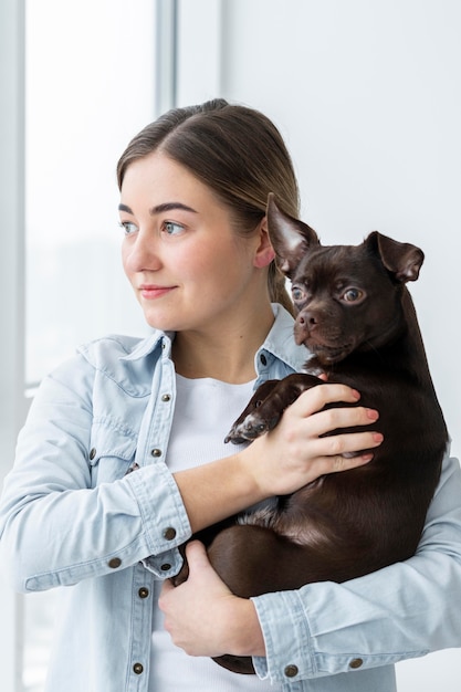 Medium Shot of a Girl Holding a Cute Dog – Free Download