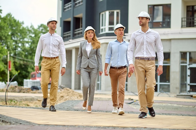 Woman and Men Walking on Construction Site – Free Download