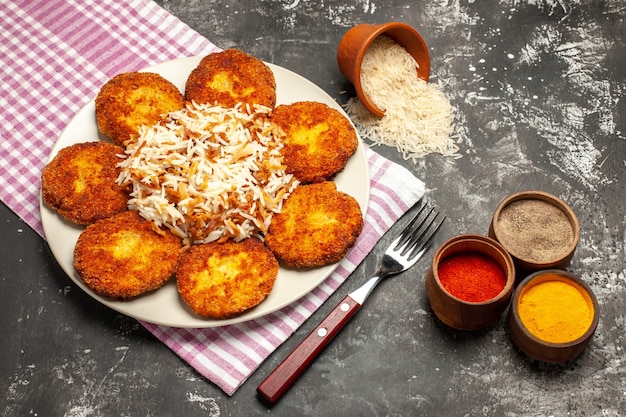 Tasty Fried Cutlets with Cooked Rice on Dark Surface – Free Stock Photo for Download