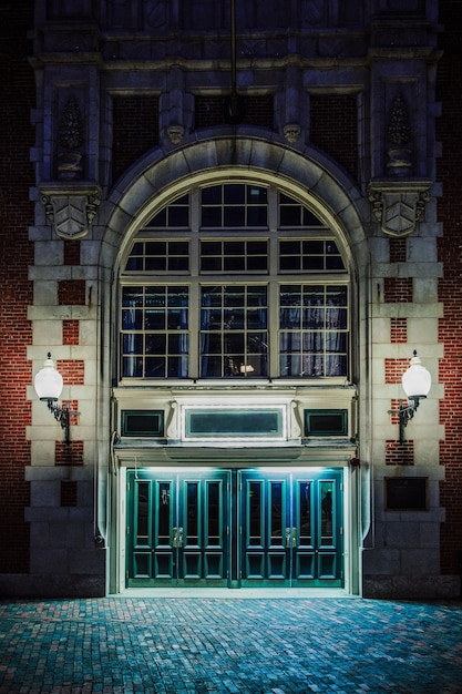 Old Brick Gothic Building Facade at Night with Lit Lamps – Free Download