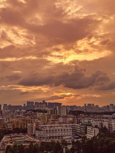 Modern and Bustling Cityscape with Sunrise Sky and Clouds – Free Download