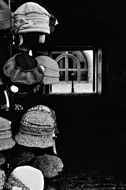 Grayscale Vertical Shot of Hats on a Tall Hanger in the City Street – Free Download