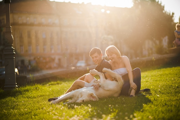 Joyful Couple Enjoying Time with Their Dog on a Sunny Day – Free Download