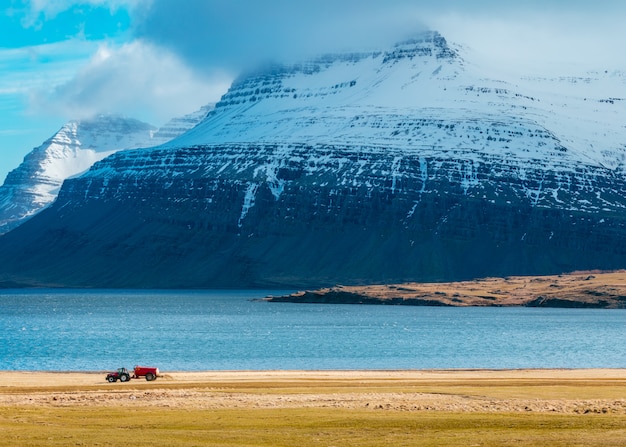 A Tractor in a Field Surrounded by Majestic Snowy Mountains – Free Stock Photo, Download for Free