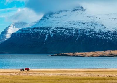 A Tractor in a Field Surrounded by Majestic Snowy Mountains – Free Stock Photo, Download for Free