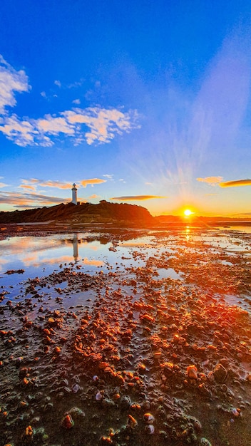 Coastline Lighthouse at Sunset – Free Download