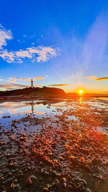 Coastline Lighthouse at Sunset – Free Download