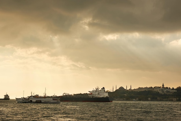 Historical Eastern-Style Buildings and Cargo Ships Under a Cloudy Sky – Free Download