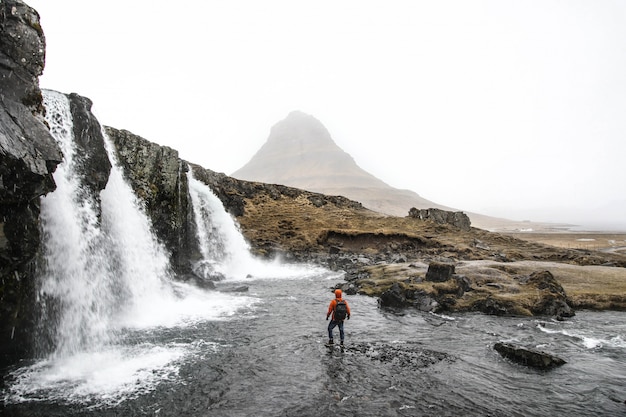 Stunning Photo of a Person by Cascading Waterfalls – Free Download