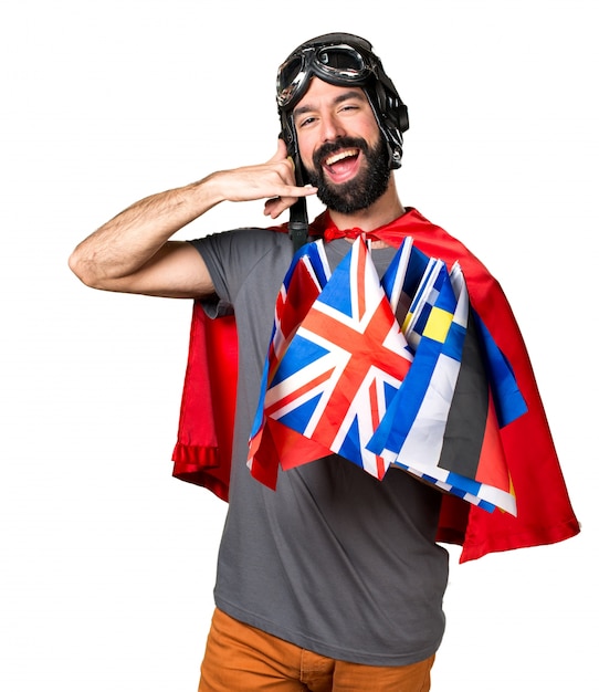 Superhero Making Phone Gesture Surrounded by Flags – Free Download