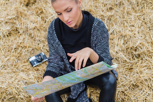 Woman Holding Map in Hay – Free Download