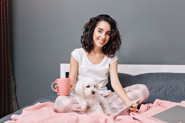 Joyful Young Woman with Curly Brunette Hair Chilling at Home with Little Dog – Free Download