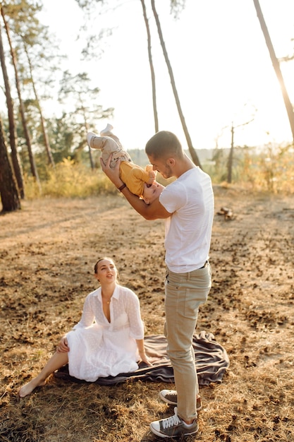 Young Family Portrait in Autumn Pine Forest – Free Download