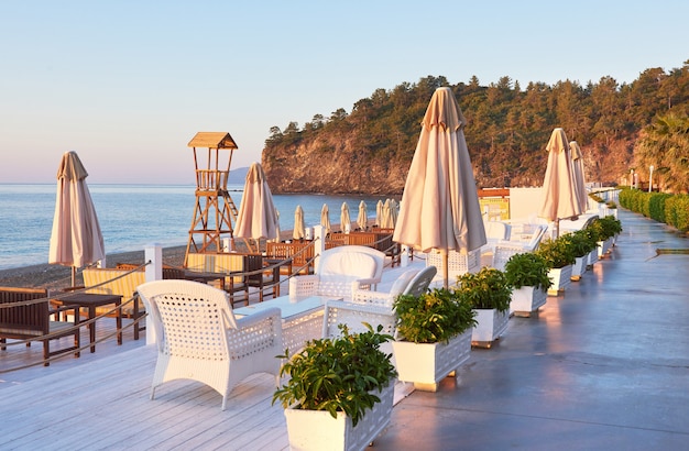 Scenic View of a Private Sandy Beach with Sun Beds and Parasols by the Sea and Mountains – Free Download