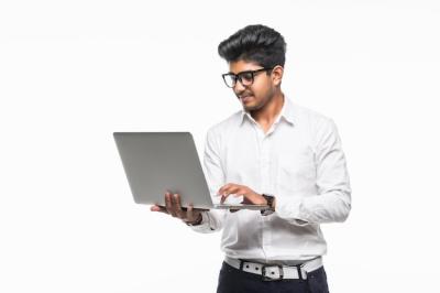 Indian Young Man Using Laptop Isolated on White Wall – Free Download