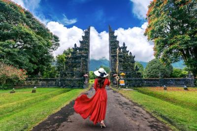 Woman Walking Through a Grand Entrance Gate in Bali, Indonesia – Free Stock Photo for Download